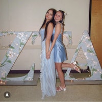 two girls posing in front of a large letter z