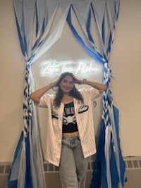 a girl posing in front of a blue and white banner
