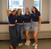 a group of women in denim skirts posing for a picture