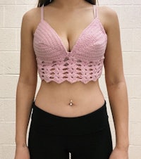 a woman wearing a pink crochet bra top