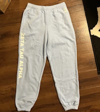 a pair of blue sweatpants with the word alpha on them