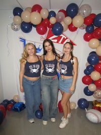 three women standing in front of balloons