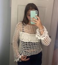 a woman taking a selfie in a white crochet top