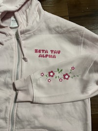 a pink hoodie with flowers on it