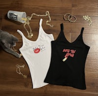 two women's tank tops with a cat next to them