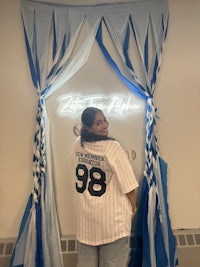 a girl standing in front of a blue and white banner
